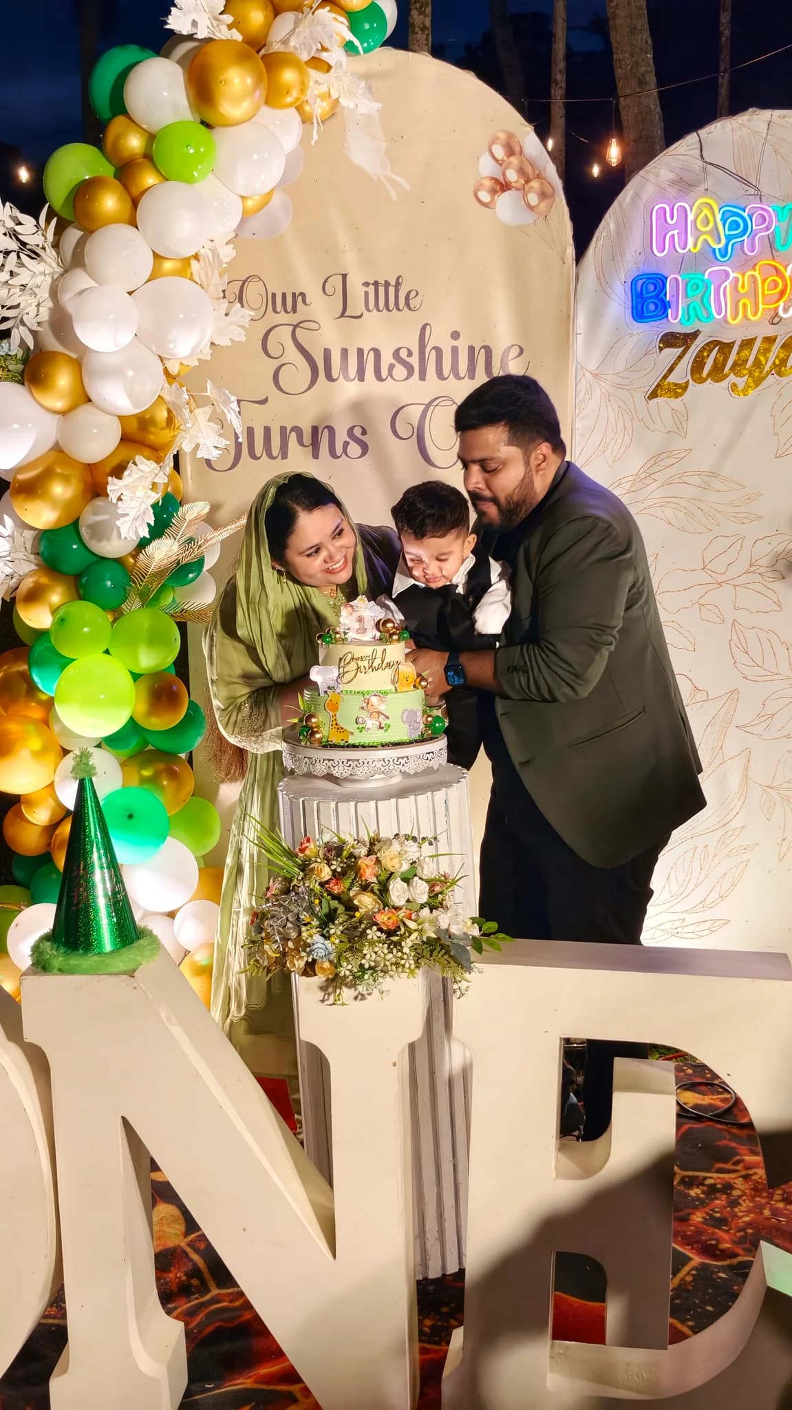 Parents and child gathered around a first birthday cake at Terrabithia in Thrissur